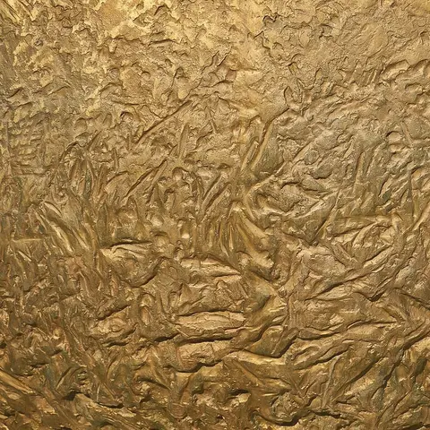 Close photograph of a brushed brass surface in a muted gold tone.